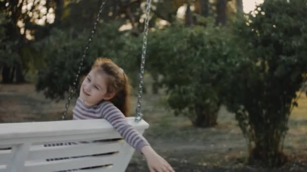 Mała Ośmiolatka Bawiąca Się Białym Huśtawce Cichym Zadrzewionym Tle Parku — Wideo stockowe