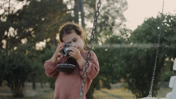 かわいい女の子は レトロカメラで自然の最初の写真を撮ります 子供の頃に写真を撮る — ストック動画