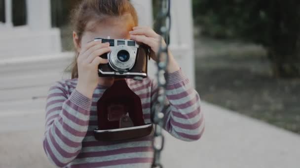 귀여운 소녀는 레트로 카메라로 자연의 그녀의 사진을 찍습니다 사진에서 만들기 — 비디오