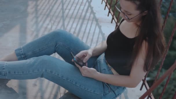 Close Uma Mulher Vestindo Óculos Olhando Para Smartphone Enquanto Sentado — Vídeo de Stock