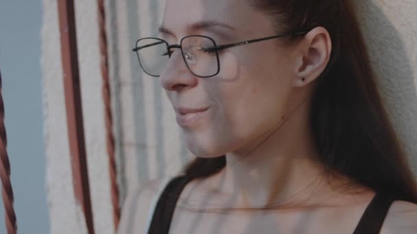 Γυναίκα Γυαλιά Στο Μπαλκόνι Του Μπλοκ Χαλαρώνοντας Και Αναπνέοντας Καθαρό — Αρχείο Βίντεο