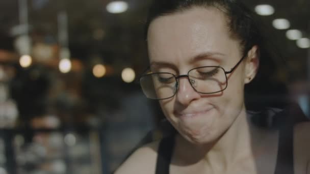 戴眼镜的女人在咖啡店里喝卡布奇诺咖啡 — 图库视频影像