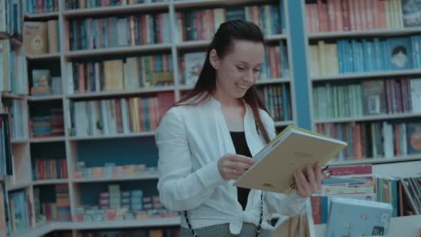 Gülümseyen Genç Kadın Boş Zamanlarını Kitapçıda Geçirip Satın Alacak Yeni — Stok video