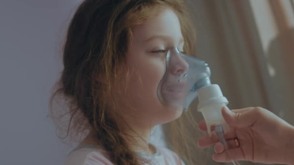 小さな女の子が病気を治療するために直面する呼吸マスクを持っている介護母親 呼吸マスクによる吸入のための医療機器 スーパーママのコンセプト — ストック動画