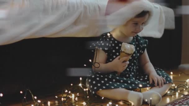 Nettes Kleines Mädchen Mit Weihnachtsmütze Das Auf Der Weihnachtsfeier Eis — Stockvideo