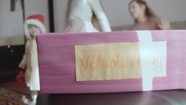 Charity Christmas Box Auf Dem Hintergrund Von Fröhlich Tanzenden Kleinen — Stockvideo