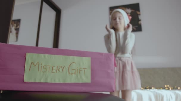 神秘的礼品盒小女孩摆出姿势猜神秘盒子里有什么 圣诞前夕的儿童游戏 — 图库视频影像