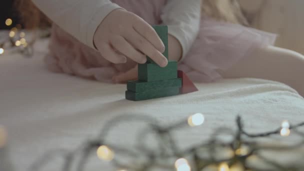 カラーコンストラクターピースでクリスマスツリーを構築する小さな女の子 — ストック動画