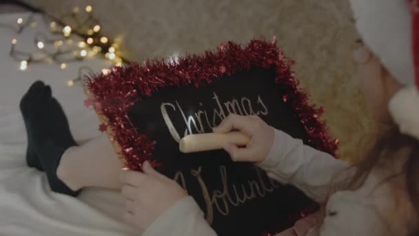 一个小女孩拿着印有圣诞志愿服务字样的黑板 圣诞节志愿服务概念 — 图库视频影像