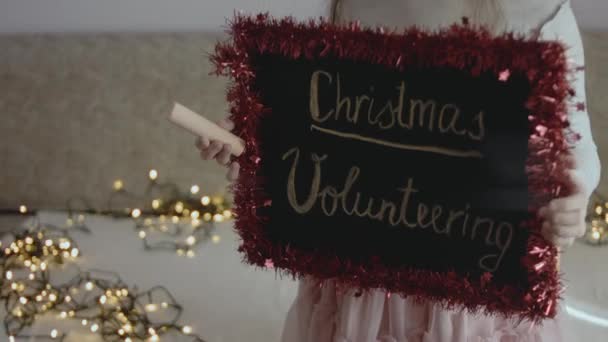 Дошка Написом Різдвяна Волонтерка Яку Тримала Маленька Дівчинка Різдвяна Концепція — стокове відео