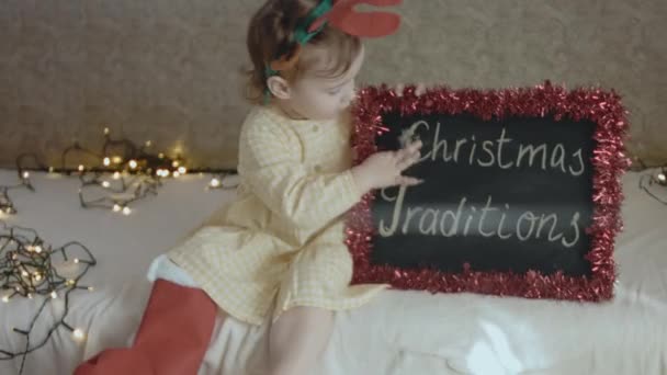 Menina Está Divertindo Com Quadro Negro Com Inscrições Tradições Natal — Vídeo de Stock