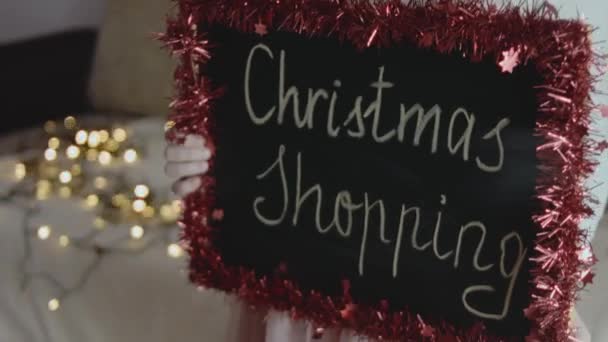 Lavagna Con Iscrizione Shopping Natalizio Tenuto Una Bambina Luci Natale — Video Stock