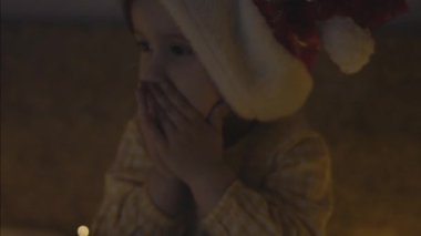 Noel Baba şapkalı küçük bir kız bir şey diliyor. Küçük kız Noel arifesinde dua ediyor. El bilgisayarı atışı