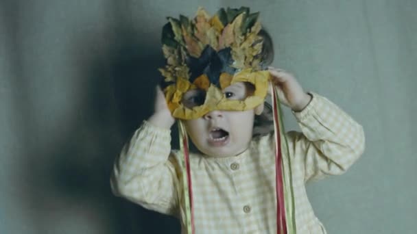 Kleinkind Mit Herbstblattmaske Die Die Ohren Mit Den Händen Schließt — Stockvideo