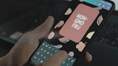 Akıllı telefondaki GDO olmayan meyve yazıları. Mobil uygulama üzerinde bir reklam tasarımı yapan tasarımcı
