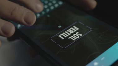 Akıllı telefondaki topraktaki doğurganlık yazıları. Mobil uygulama üzerinde bir reklam tasarımı yapan tasarımcı.