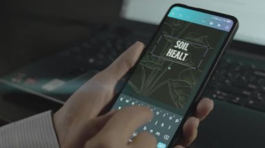 Akıllı telefondaki toprak sağlığı yazıtları. Mobil uygulama üzerinde bir reklam tasarımı yapan tasarımcı.