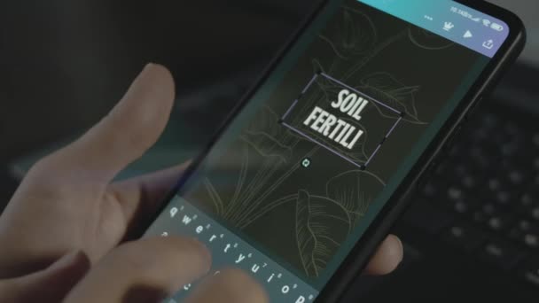 智能手机上的土壤肥力铭文 在移动应用程序上进行广告设计的设计人员 — 图库视频影像