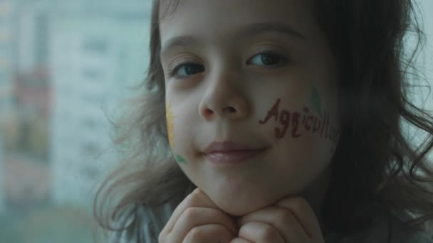 快乐的小女孩 脸上挂着葵花画和农业题词 农业概念 — 图库视频影像