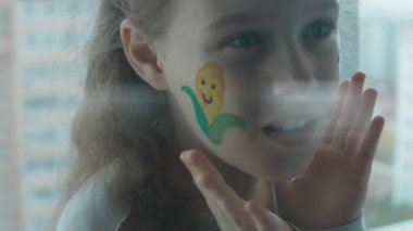 Şirin, neşeli bir kızın yüzünde mısır ve traktör çizimleri. Şaşırma duygusunu gösteriyor. Tarım kavramı