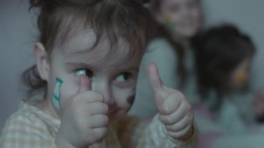 Tarım temalı çizimleri olan sevimli, neşeli küçük bir kız. Süper işareti göstermek ve komik surat yapmak. Tarım kavramı