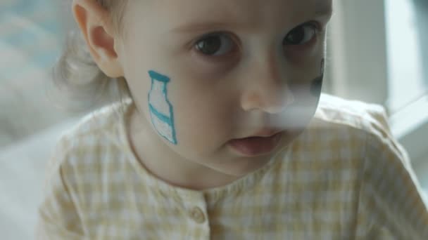 Yüzünde Süt Şişesi Inek Çizimleri Olan Sevimli Küçük Bir Kız — Stok video