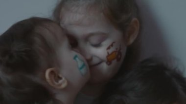 Tarım temasında çizimleri olan üç sevimli, neşeli küçük kız. Bir kız kardeş diğerini öper. Tarım kavramı