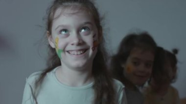 Tarım temasında çizimleri olan üç sevimli, neşeli küçük kız. Komik suratlar yapıyorsun. Tarım kavramı