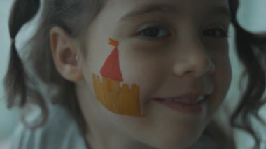 Ortaçağ şatosu şirin küçük bir kızın yüzüne resim çiziyor. Mimarlık konsepti
