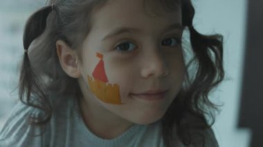 Yüzüne ortaçağ kalesi çizen neşeli küçük kız. Hava öpücüğü veriyorum. Mimarlık konsepti