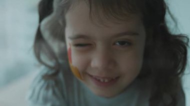 Yüzüne ortaçağ şatosu çizilmiş neşeli küçük bir kız. Mimarlık konsepti