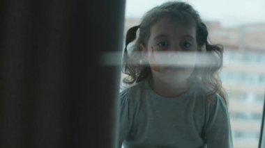 Yüzüne ortaçağ şatosu çizilmiş, kameraya bakan neşeli küçük bir kız. Mimarlık konsepti