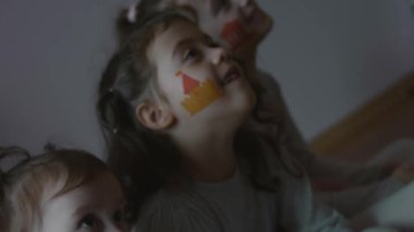 Yüzlerinde mimari temalı çizimlerle gülümseyen üç küçük kız. Mimarlık konsepti
