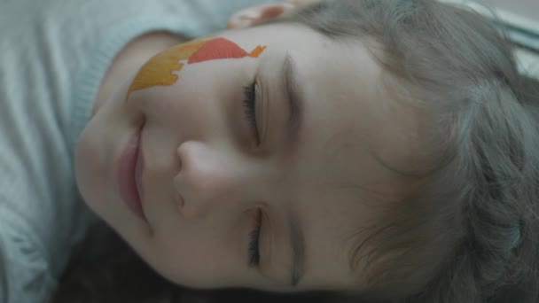 Веселая Маленькая Девочка Средневековым Замком Нарисованным Лице Лежала Закрытыми Глазами — стоковое видео