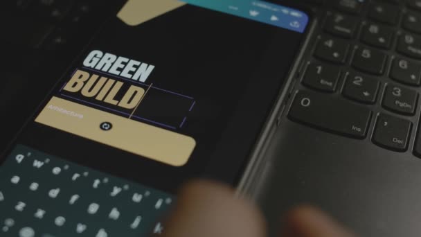 智能手机上的绿色建筑题词 在移动应用程序上进行广告设计的设计人员 — 图库视频影像