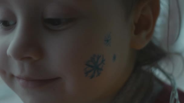 Gadis Kecil Yang Ceria Dengan Lukisan Bertema Natal Wajahnya Kepingan — Stok Video