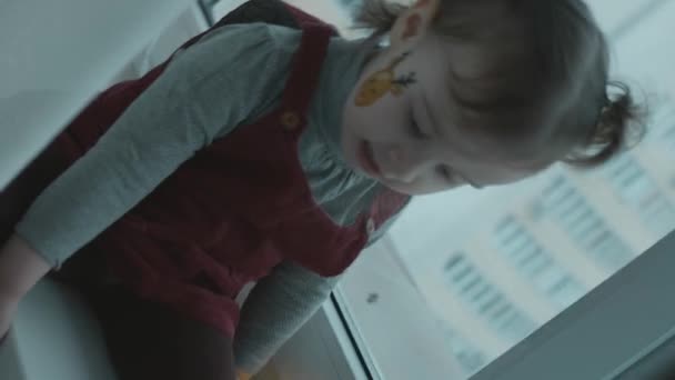 Fröhliches Kleinkind Mit Weihnachtlicher Bemalung Gesicht Schneeflocken Und Rentiermalerei Gesicht — Stockvideo