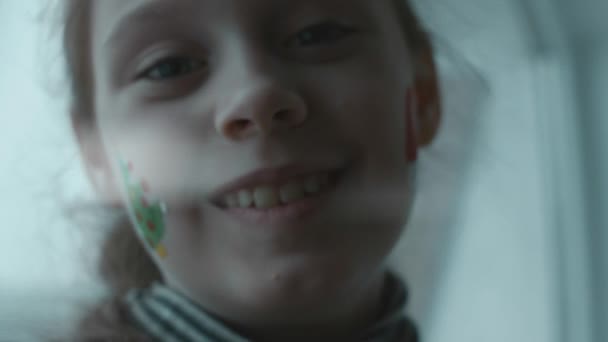 Fröhliches Kleines Mädchen Mit Weihnachtlichen Bildern Gesicht Weihnachtsbaum Und Weihnachtsmützen — Stockvideo