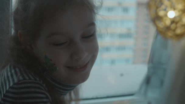 Fröhliches Kleines Mädchen Mit Weihnachtlicher Bemalung Gesicht Weihnachtsbaumbemalung Gesicht Weihnachtskonzept — Stockvideo