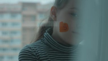 Yüzünde bir yığın altın sikke olan ciddi küçük bir kız. Bankacılık, mali eğitim ve mevduat kavramı