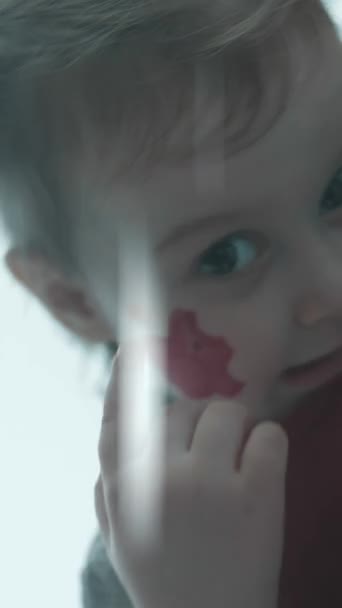 顔にピギーバンクの絵を描いた 陽気な幼児の女の子 絵画に指がついている 金融教育 預金コンセプト — ストック動画