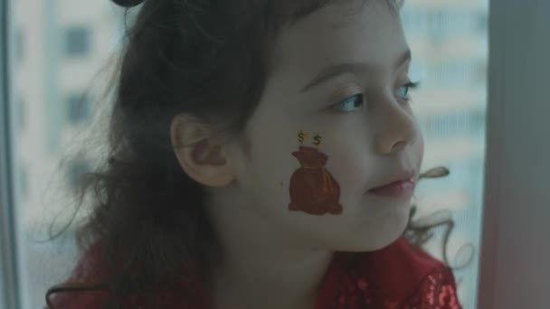 Σοβαρό Κοριτσάκι Ένα Τσουβάλι Χρυσά Νομίσματα Ζωγραφισμένο Στο Πρόσωπό Της — Αρχείο Βίντεο