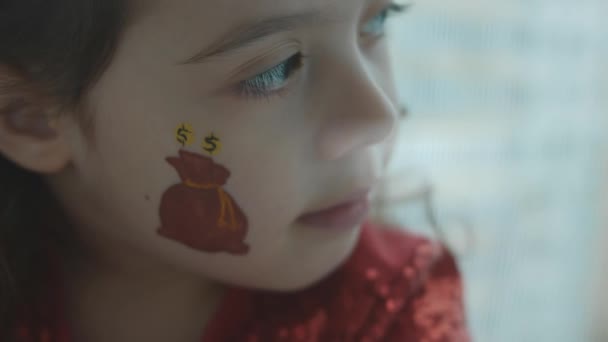 Een Zak Gouden Munten Het Gezicht Van Een Klein Meisje — Stockvideo