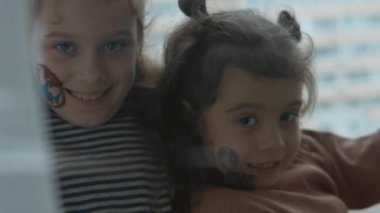 Yüzlerinde kargo ve nakliye resimleri olan iki neşeli küçük kız. Komik suratlar yapıyorsun. Kargo ve nakliye konsepti