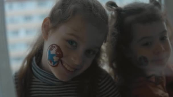 2人の陽気な少女が貨物を持って顔に絵を描いた 貨物および船積みの概念 — ストック動画