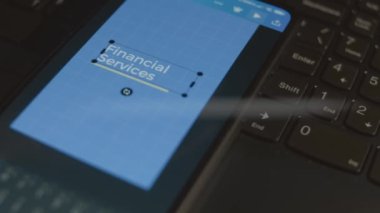 Akıllı telefondaki finansal hizmetler yazısı. Tasarımcı mobil uygulama üzerine bir reklam tasarımı yapıyor. Bankacılık kavramı.