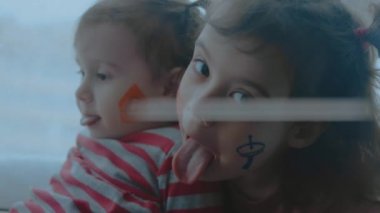 Yüzlerinde iletişim sembolleri olan iki neşeli küçük kız. Komik suratlar yapıyorsun. İletişim konsepti