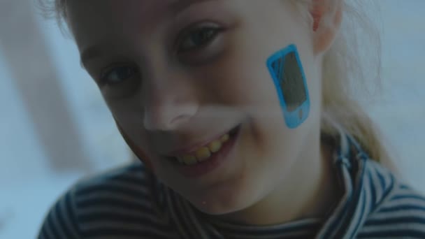 Fröhliches Kleines Mädchen Mit Smartphone Symbolbemalung Gesicht Kommunikationskonzept — Stockvideo
