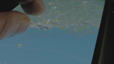 Akıllı telefon ekranında küresel haritada online uçuş takibi. Helsinki, Finlandiya. Kargo, kargo ve lojistik konsepti.