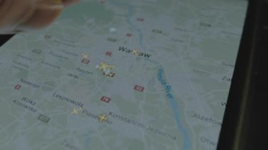Akıllı telefon ekranında küresel haritada online uçuş takibi. Varşova, Polonya. Kargo, kargo ve lojistik konsepti.